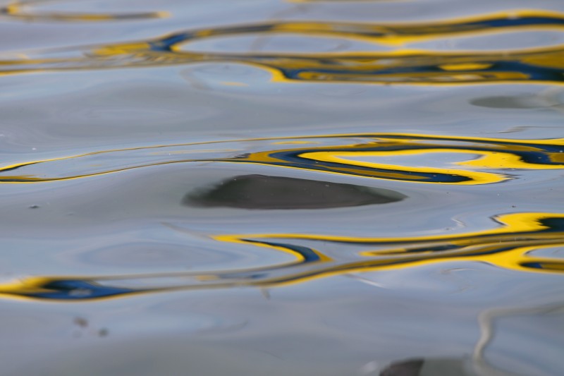 reflets jaune et bleu sur lac, bulle dans la vague