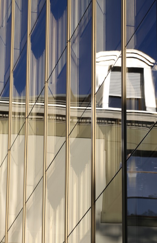 reflet du toit et de la fenêtre d'un immeuble sur une parois vitrée