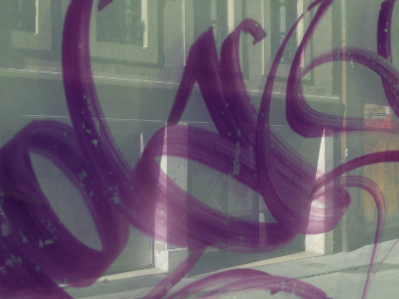 20110923220154-0ba7b6c2 tag sur une vitre qui reflète une façade d'immeuble