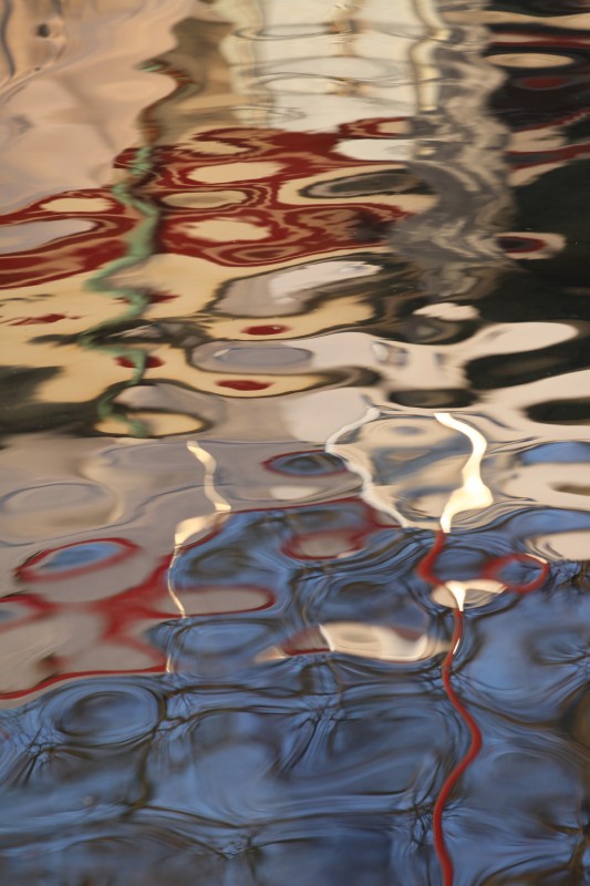 reflets rouge, bleu, beige dans l'eau du lac, effet de peinture abstraite