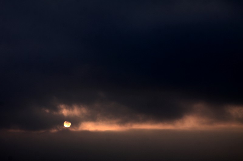 soleil rond derrière les nuages, ligne lumineuse entre les nuages