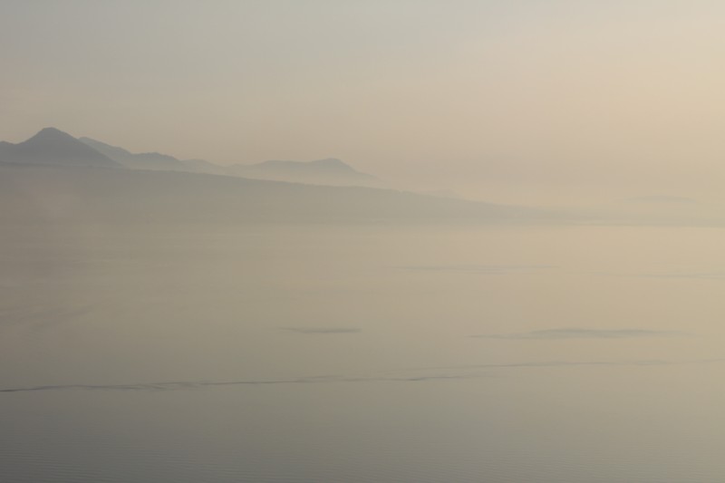 paysage d'une étendue d'eau en premier plan avec montagnes en arrière-plan, brume au-dessus du lac, Lac Léman