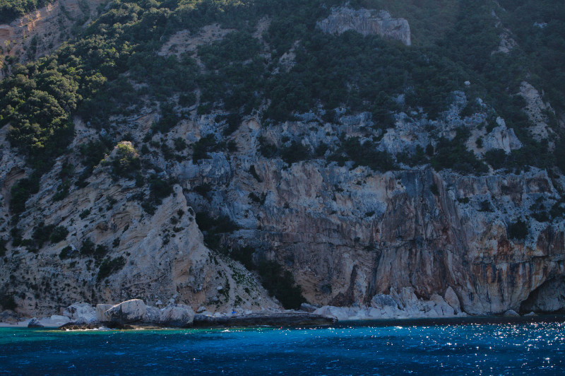 vue d'une falaise au bord de la mer, en Sardaigne, avec eau turquoise et scintillante de la mer