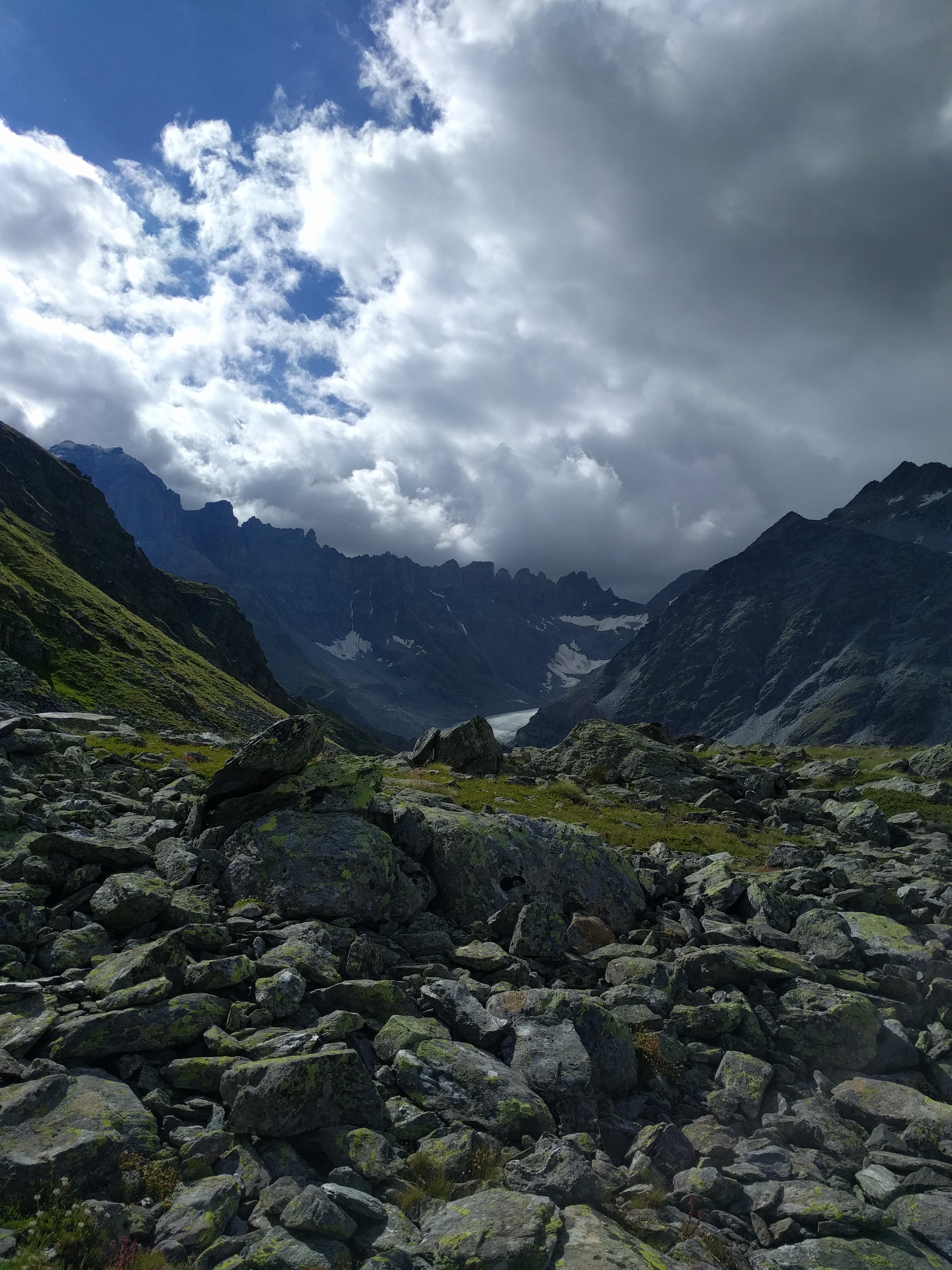 Pierres, cirque de montagnes et ciel nuageux