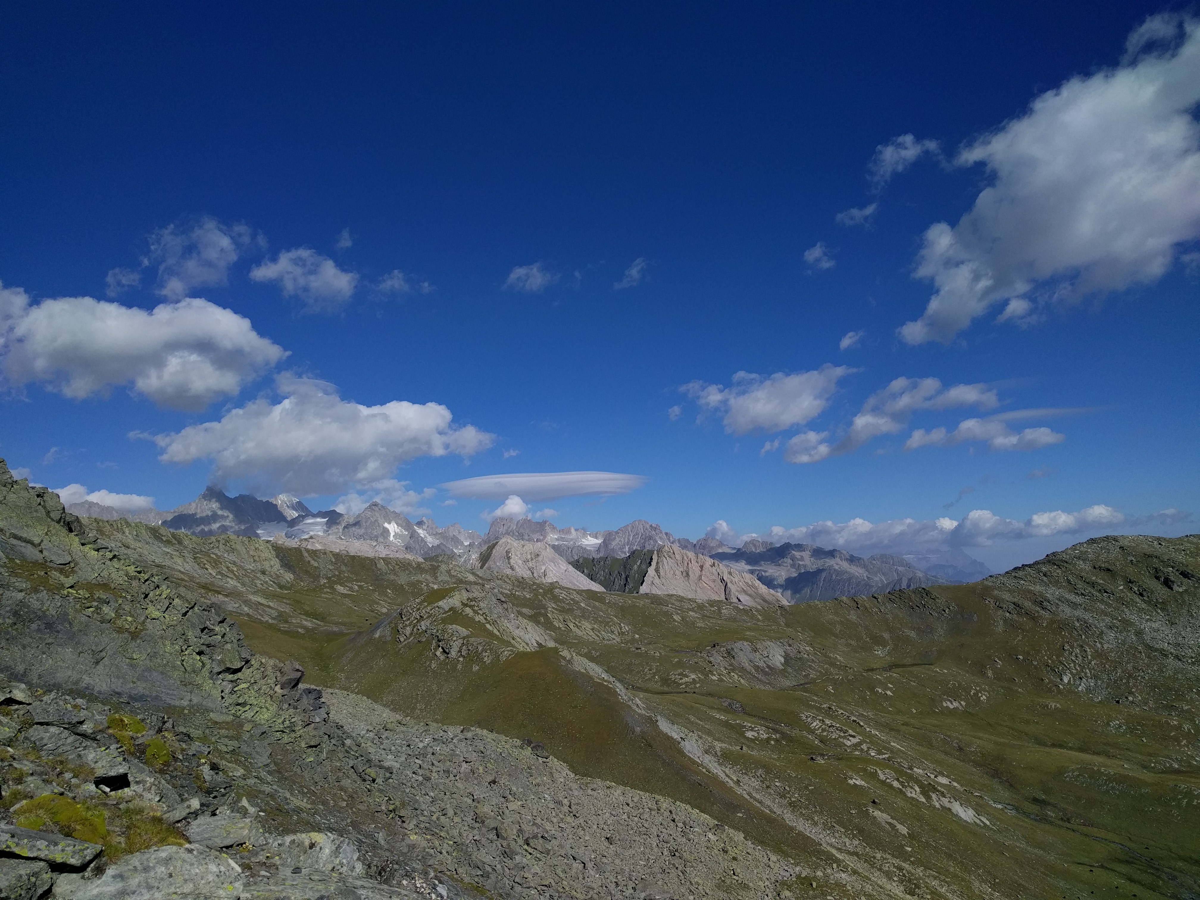 Crête, rocher, pâturages, et montagnes au loin